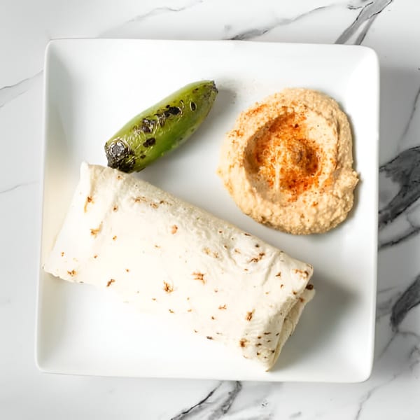 Sepan Chicken's Mediterranean plate with a wrap, hummus, and a grilled green pepper.